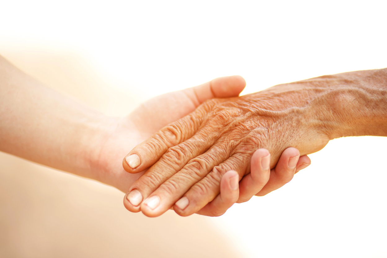 Young Person Holding the Hand of an Elderly Person 